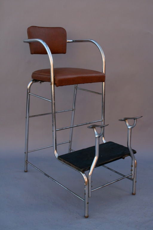 Sculptural shoe shine chair with tubular chrome frame.