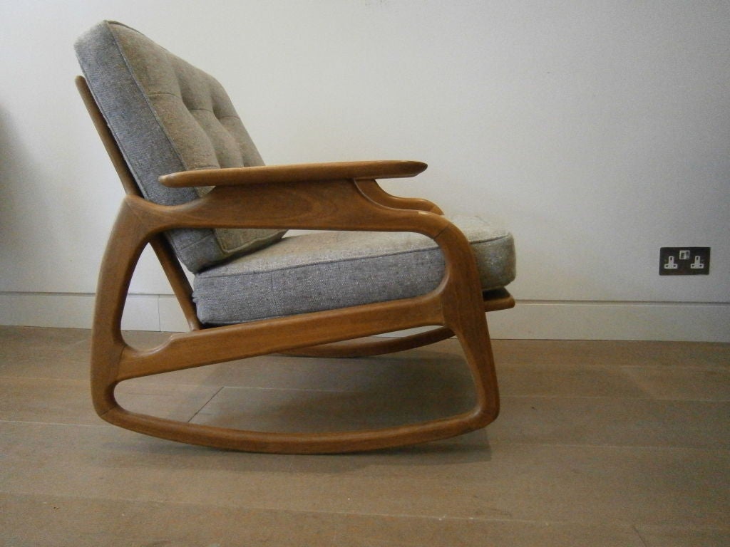 A mid-century wood framed rocking chair of interesting design the removable cushions of wool tweed piped, stitched and buttoned. A pair of matching armchairs are available (see illustration on shopfront)