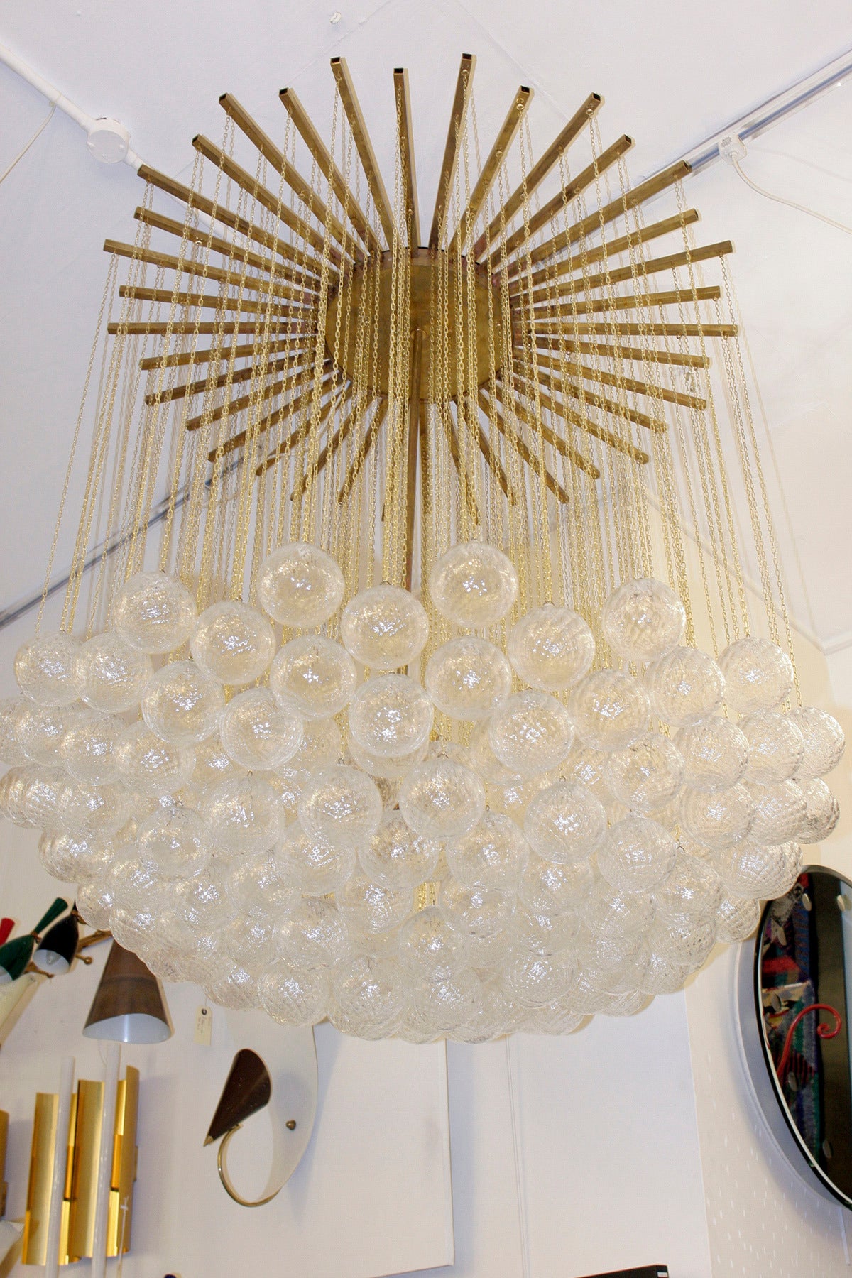 Blown Murano glass spherical components held on brass chains suspended from a brass star burst structure. Made in Italy.