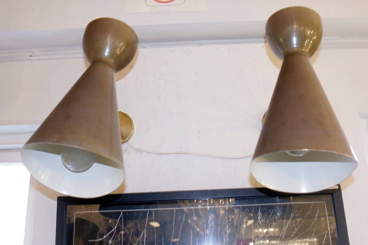 A pair of Cono wall lights, handmade brass and enamelled bronzed articulating up and down lighter shade, Italian design.