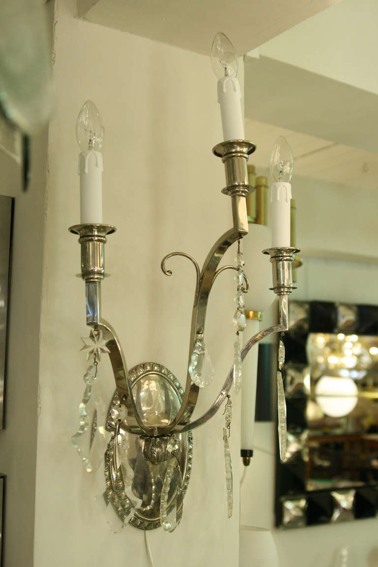 A pair of wall lights, nickel plated metal with crystal drops, circa 1940s, French.