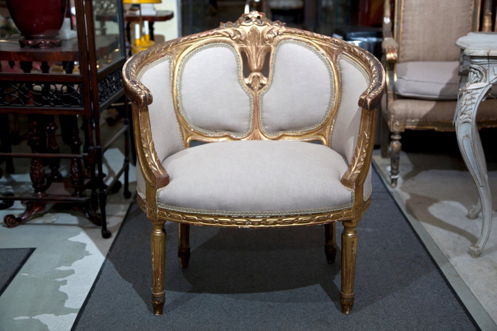 Pair of attractive French Louis XV style gilded bergere chairs or marquises, circa 1920s in original gilding, the domed back with carved foliage center crest, curved-in arms, newly upholstered in linen and burlap in the rear, raised on circular legs.