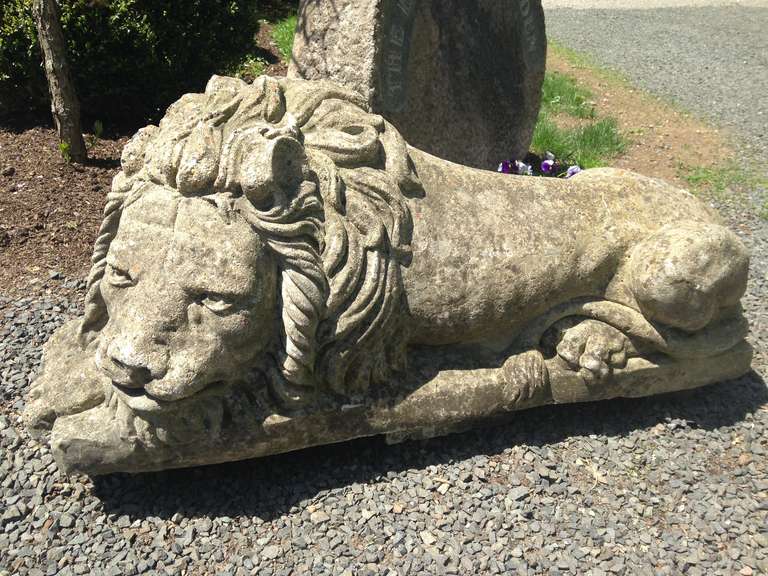 These wonderful well-weathered cast stone lions comprise a proper (opposing) pair and are modeled after the famous Antonio Canova Lions that guard Pope Clement XIII's tomb. In very good condition, there is an old repair to one tail and a weathered