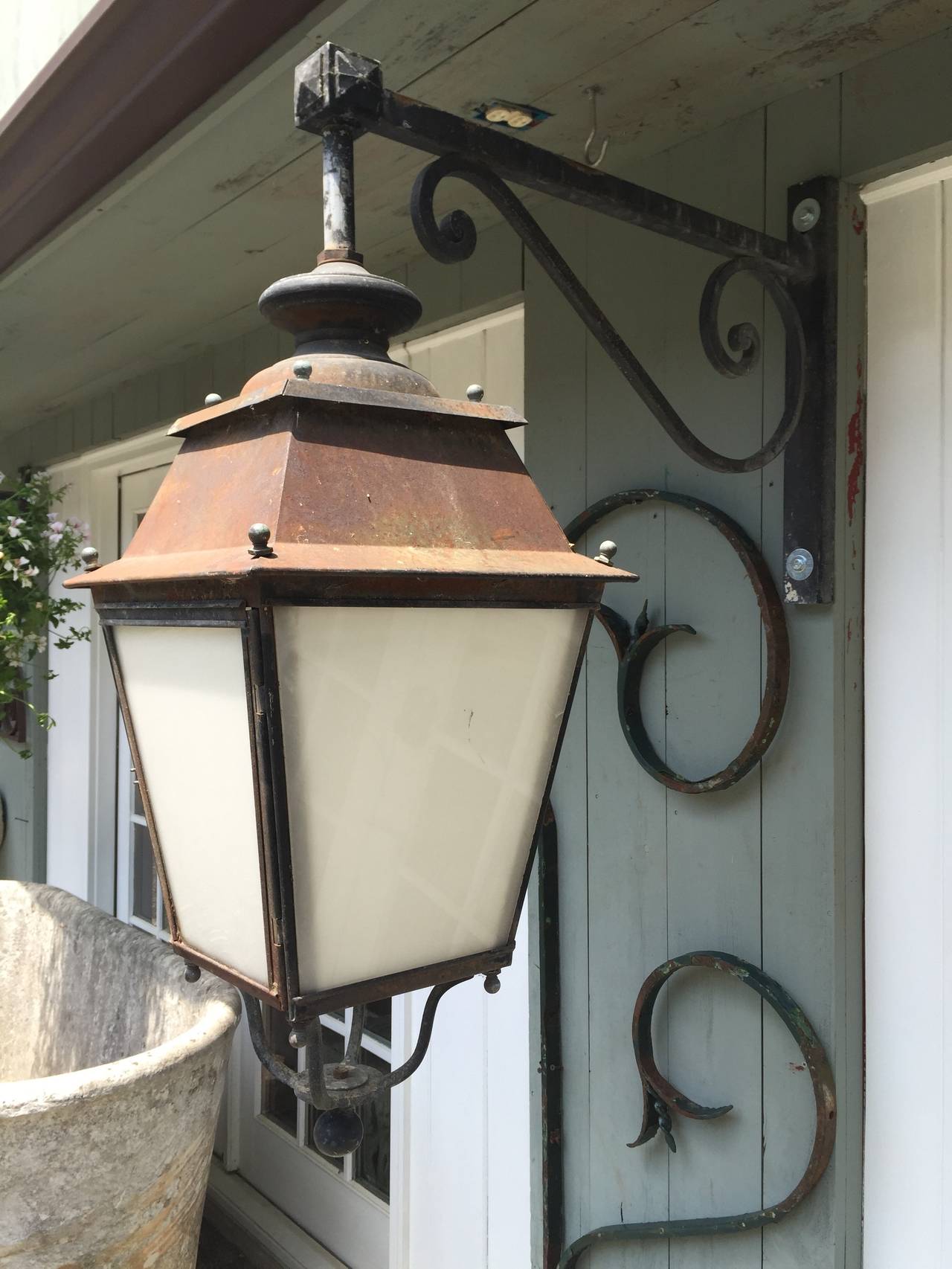 Simply classic! These French street lanterns are made of steel and feature their original bronze screws, brackets and decorative bottom finials. In all original condition each lantern has a single large bulb inside with translucent white plexiglass