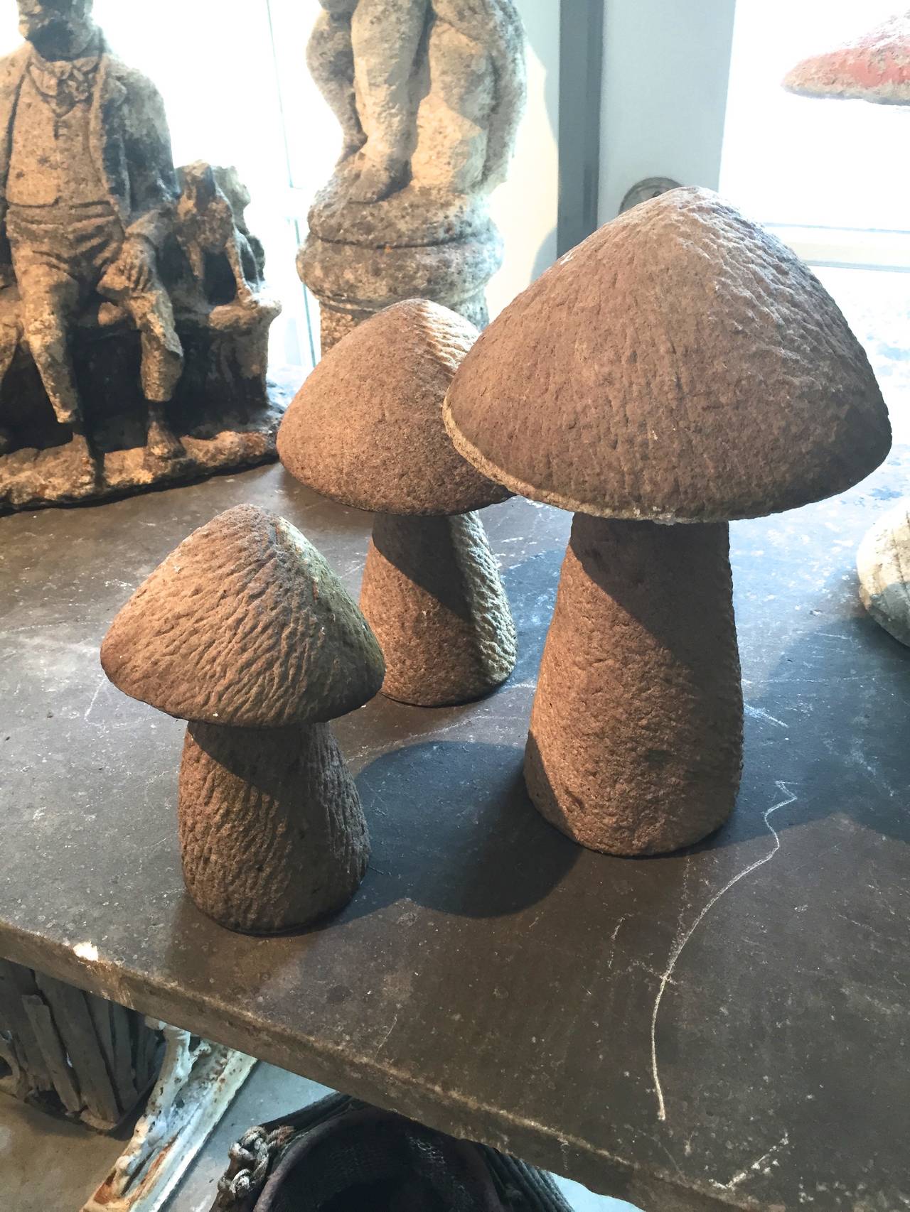 Hand-carved by a master carver, this set of three graduated toadstools, each in two parts, is just marvelous! They have a most interesting mottled side to them and, if placed in a moist and shady spot, will green and develop moss. Perfect in your