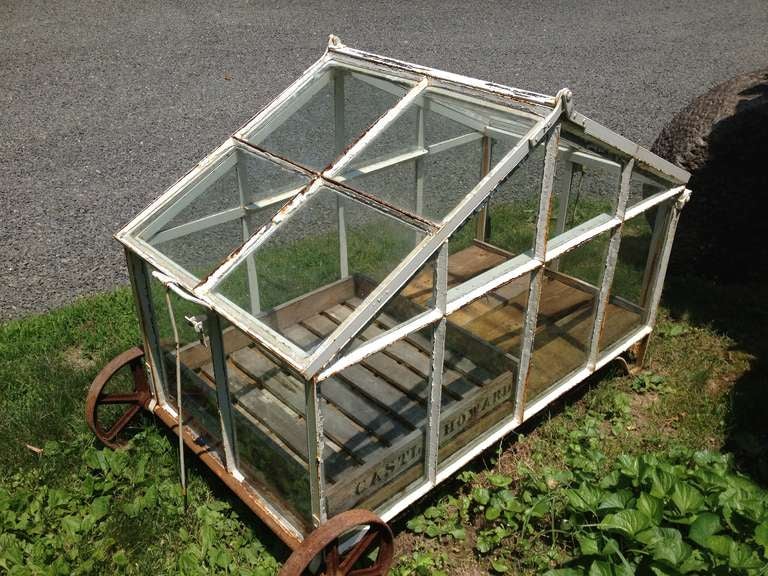 This large handmade greenhouse cart is flat out wonderful! With dual roof sections that raise up to vent the heat, antique wooden handles that allow you to wheel it around your estate, and a planked wooden floor to drain excess water, this beauty is