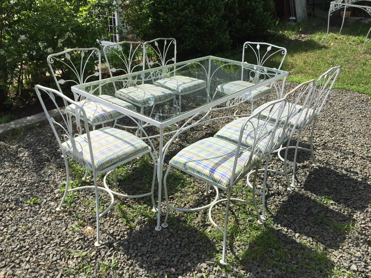 This wonderful vintage zinc-coated wrought iron dining suite in a charming ivy pattern is attributed to the famous American maker, Salterini, and dates to the mid-20th century. It features a large rectangular glass-topped table and eight side