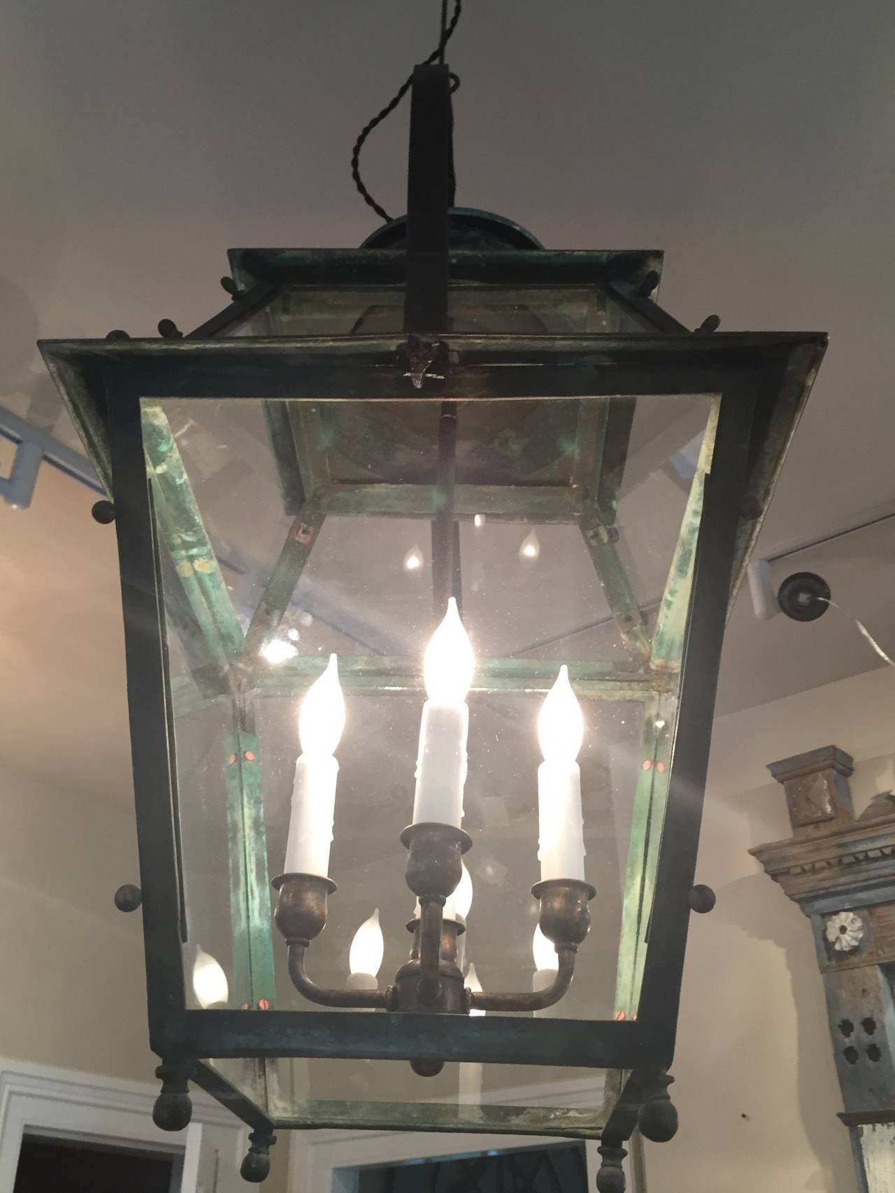 This beauty is quite early for French lanterns and dates to the mid-19th century Hand-fashioned from copper, with a prominent hand-hammered bronze handle and hook, it features a lightly verdigris surface that will only become more beautiful as the