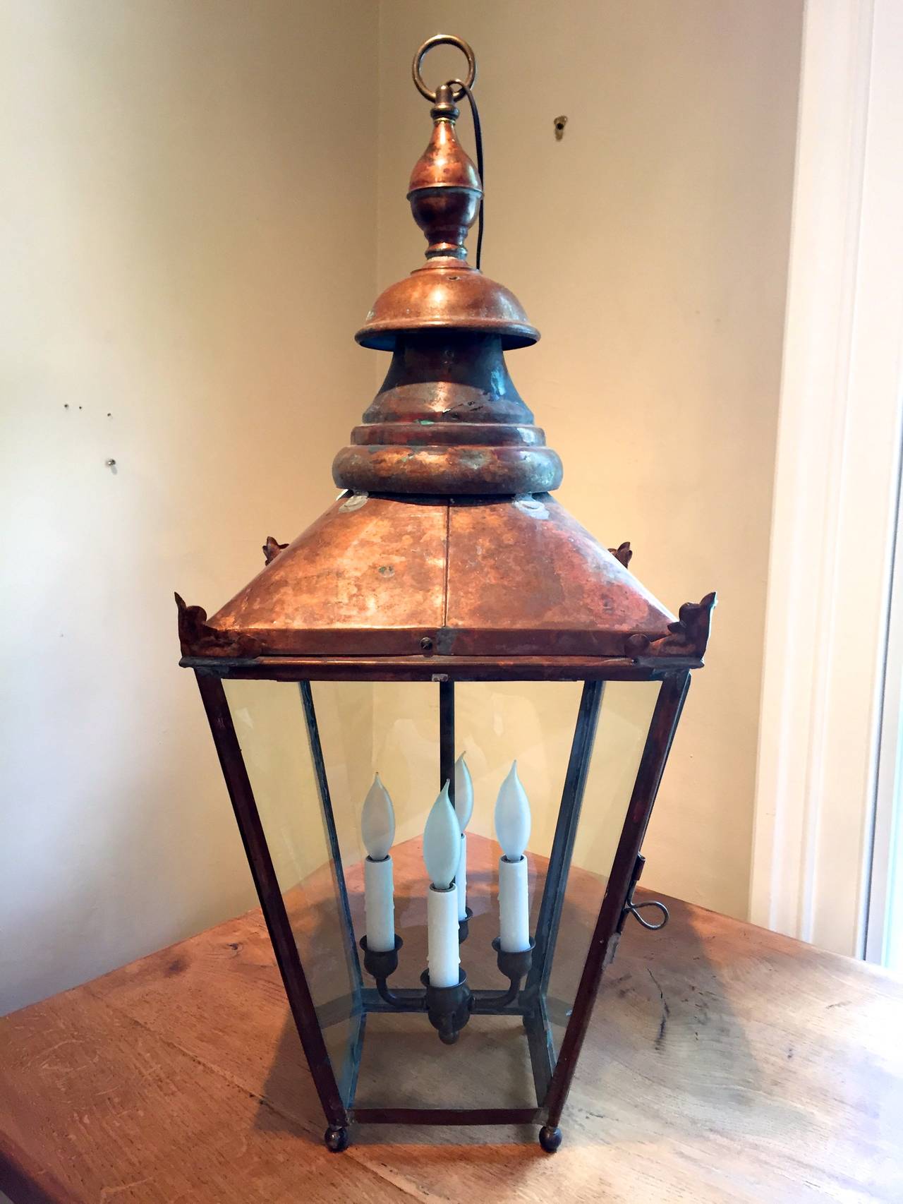 This classic English copper street lantern features a tiered finial decoration at the top, simple repoussé 