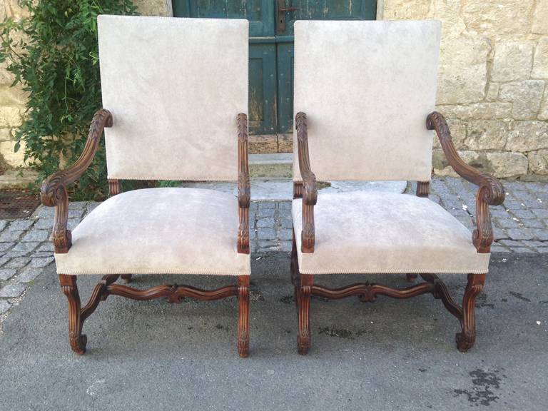 These stunning and heavily carved walnut throne chairs in the style of Louis XIII date to the mid-19th century and have been completely redone in a pale brushed grey velvet. Commodious and very comfortable with acanthus leaf carving to the arms,