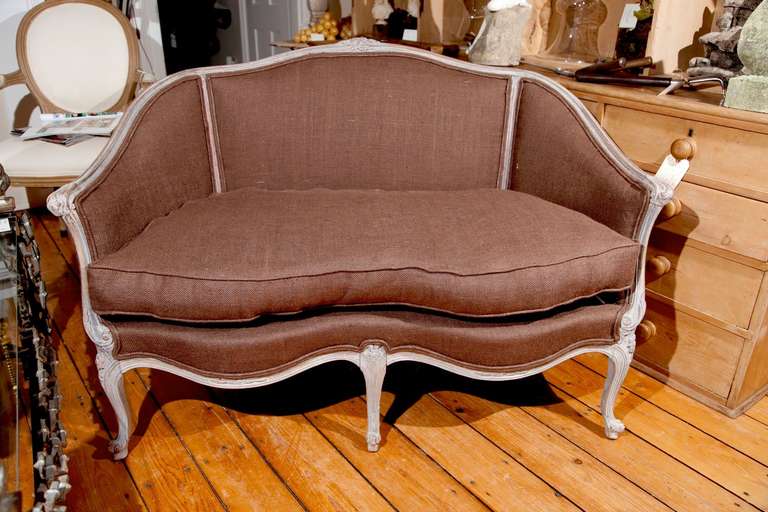 This gorgeous pair of carved fruitwood settees feature traces of pale greyish-blue paint on the frames and lovely detailing on the arms and legs. Stripped to their frames and completely redone with down-wrapped cushions and brown burlap upholstery,