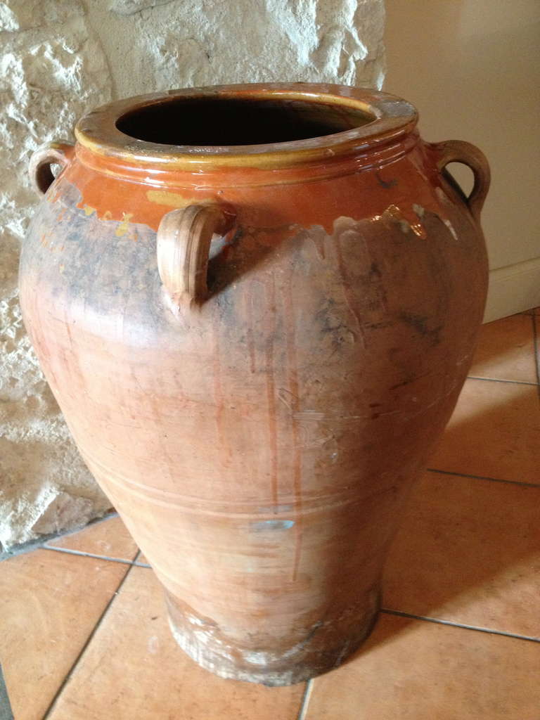 This beauty comes from the Basque area of the Pyrenees mountains that divide France and Spain and was originally used to store wine.  Hand-thrown of terracotta and featuring  four handles, it features a lovely glaze inside in shades of warm burnt