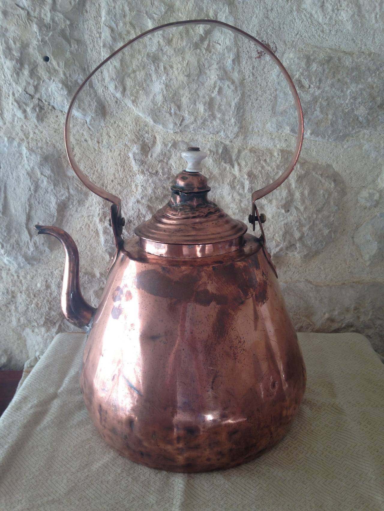 We love this kettle for its large size and beautiful patina. All hand-riveted, the lid has some dents and bruises that are typical for a piece of this age, but it is totally serviceable or perfect as a decorative piece atop a shelf. Please note that