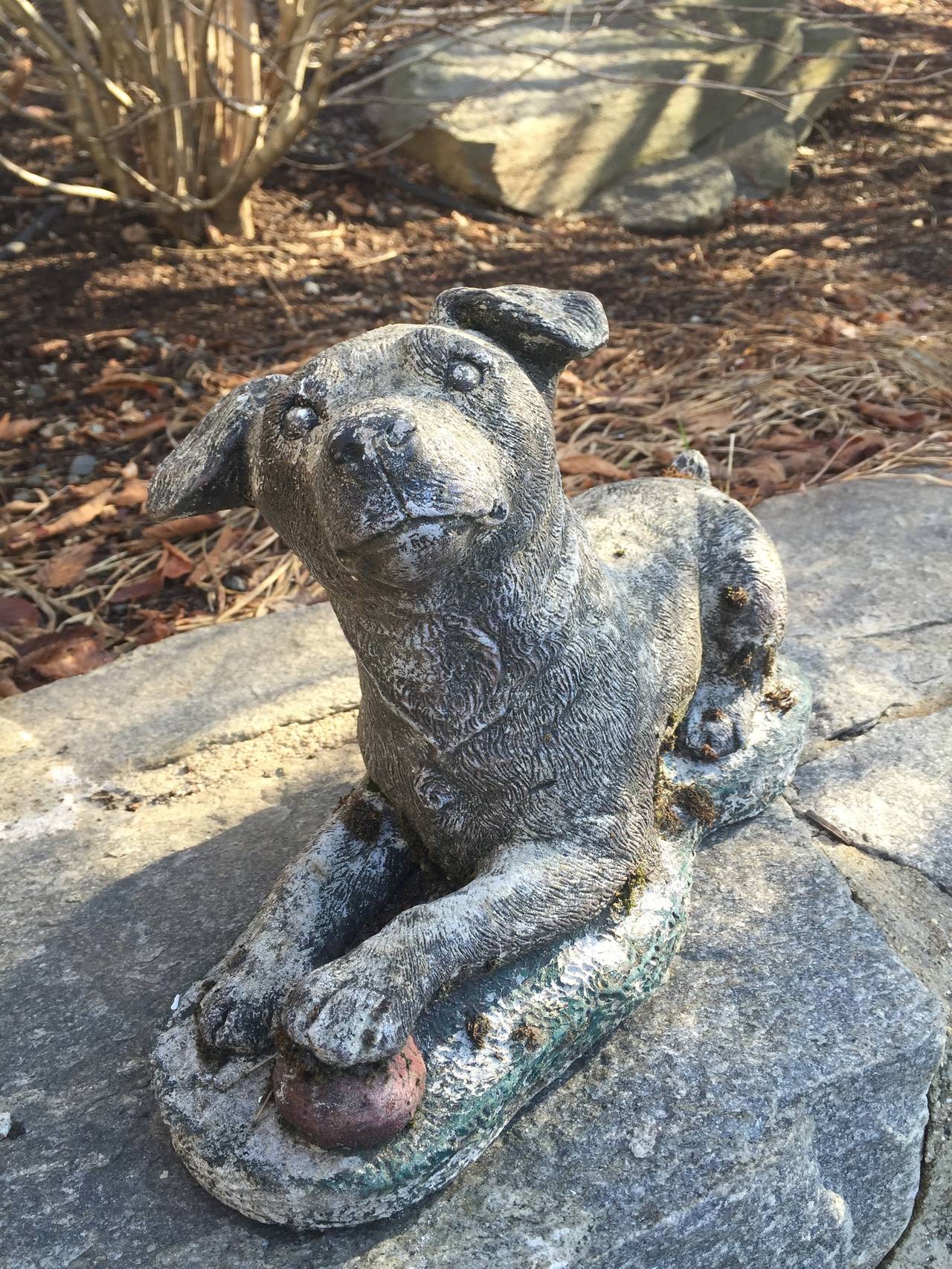 This adorable little guy is playfully posed with perked ears and his paw atop a faded red ball. Traces of older green paint remain around the base. He is in perfect condition and will give you years of enjoyment in your garden, on a wall, or perched