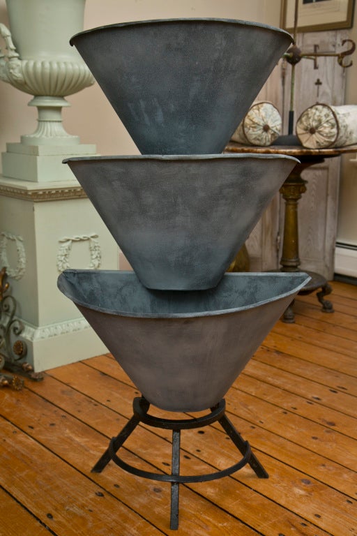 This is a great piece...highly utilitarian and with wonderful form.  Originally used to display blooms at a Parisian Flower Shop, it has a sturdy cast iron frame (19th C) and mid-20th C galvanized bins that have been painted with a zinc