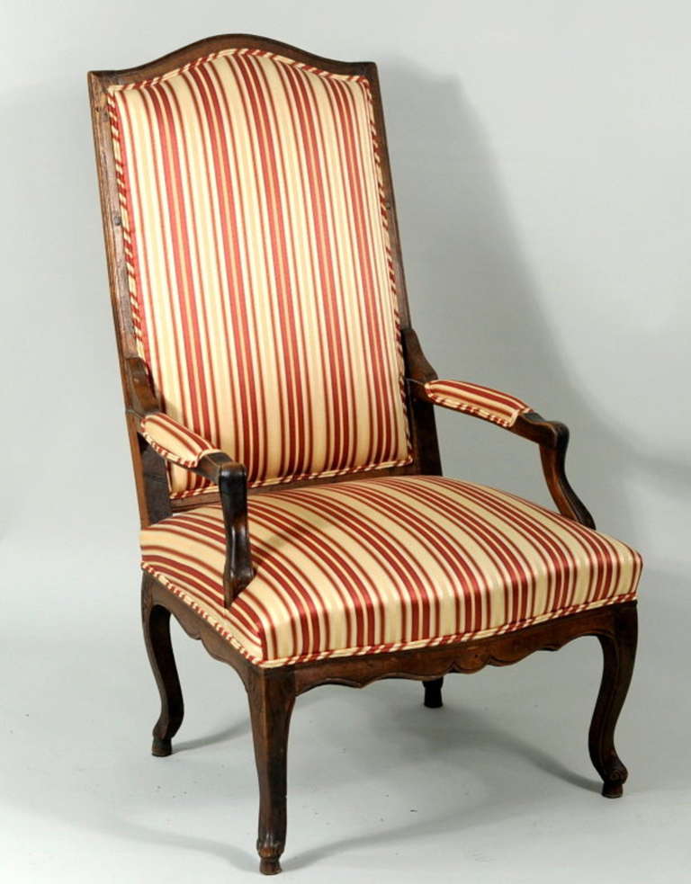 Stylish French provincial carved oak bergere chair, with high upholstered back, the frame canting to joint the shaped and modeled padded arms, above an upholstered seat raised on hooved cabriole legs. Wonderful character and compelling aspect.