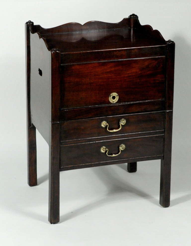 George III mahogany commode or side table, with open shelf with drop down cover, above working drawer over pull out commode section with leather covered surface. Probably England, late 19th century.