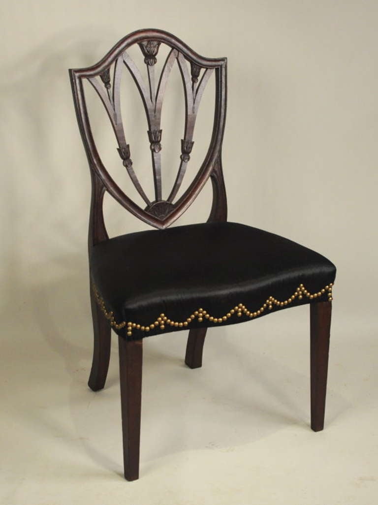 Very fine and rare Hepplewhite carved mahogany shield back side chair, the back with cove molded and beaded surround, with three intersecting vertical slats with leaf carving, above an upholstered seat raised on square tapering front legs and raking