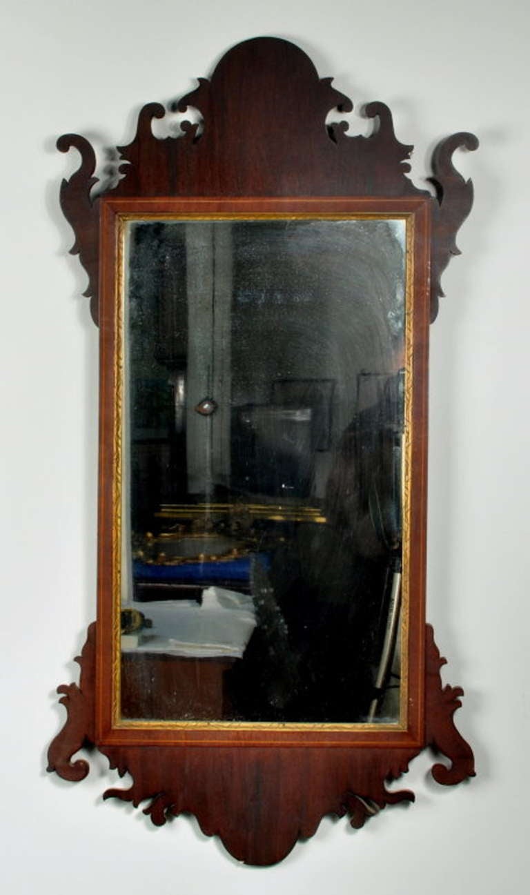 Fine Hepplewhite transitional inlaid mahogany wall mirror, with cutout frame and string inlaid crossbanded border with incised gilded and gesso inner liner, in fine original condition. Replaced backboard.
New York, circa 1795-1800.