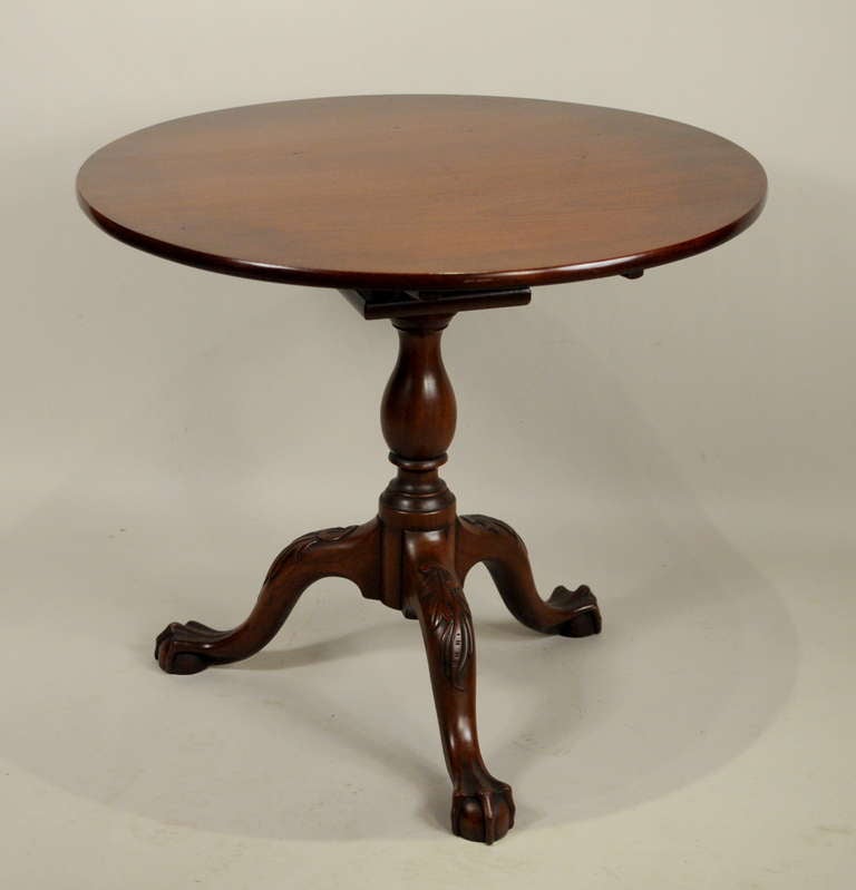 Fine Chippendale carved walnut round tea table, with bullnose edge top above a bird cage support on a baluster shaped shaft, raised on three acanthus carved cabriole legs ending in squared claw and ball feet. New York,
circa 1775-80.