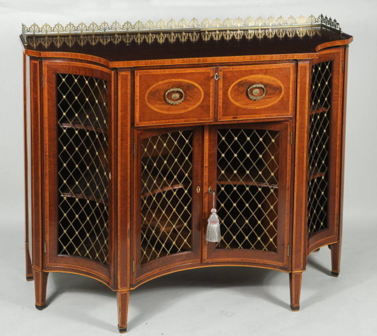 Very rare superb quality London made satinwood and inlaid butler's serving cabinet, with pierced brass galleried top above a central pull-out desk section with leather fold down writing board, above a pair of concave bronze grillwork central doors,