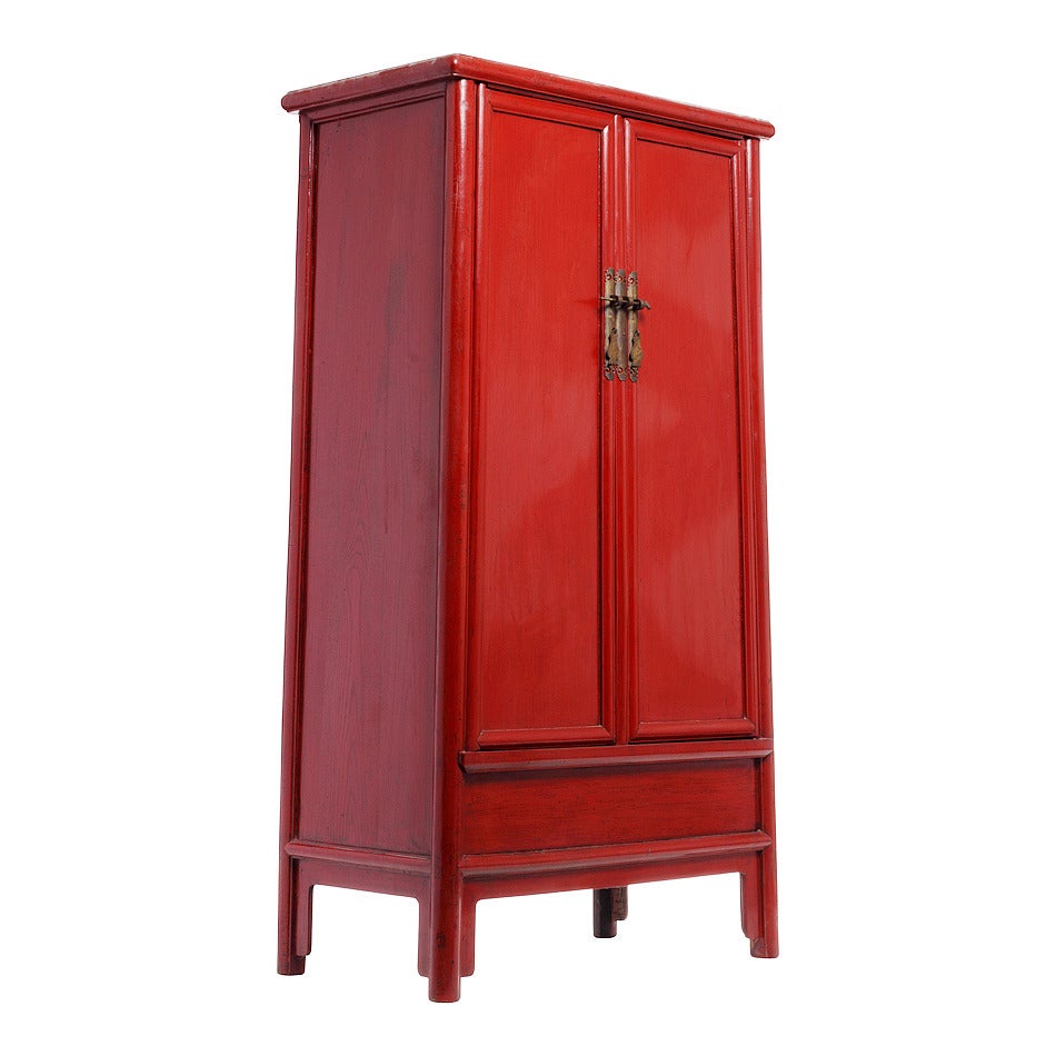 A Chinese red lacquered armoire with noodle top from the 1800s. This Chinese 19th century tapered armoire showcases a rectangular shape adorned by round edges and a noodle top overhanging on the front and sides. The tall armoire is covered with a