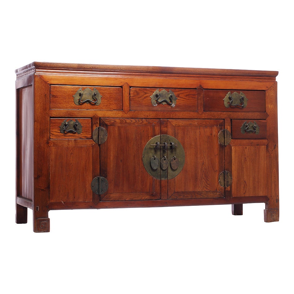 This antique five-drawer and two-door buffet was made with wood and iron hardware in China during the 19th century. The buffet adopts a typical Asian refined rectangular shape, with a molded top and scroll patterns on its legs. The buffet features