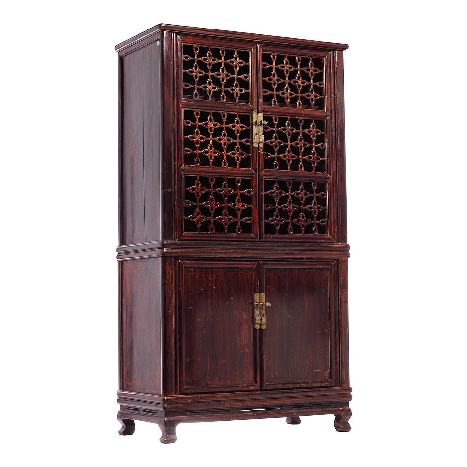 Chinese elmwood fretwork kitchen cupboard from the late 19th century. This Chinese kitchen cupboard with elmwood fretwork and metal hardware was made during the 19th century and features a dark stained patina. The top section showcases two finely