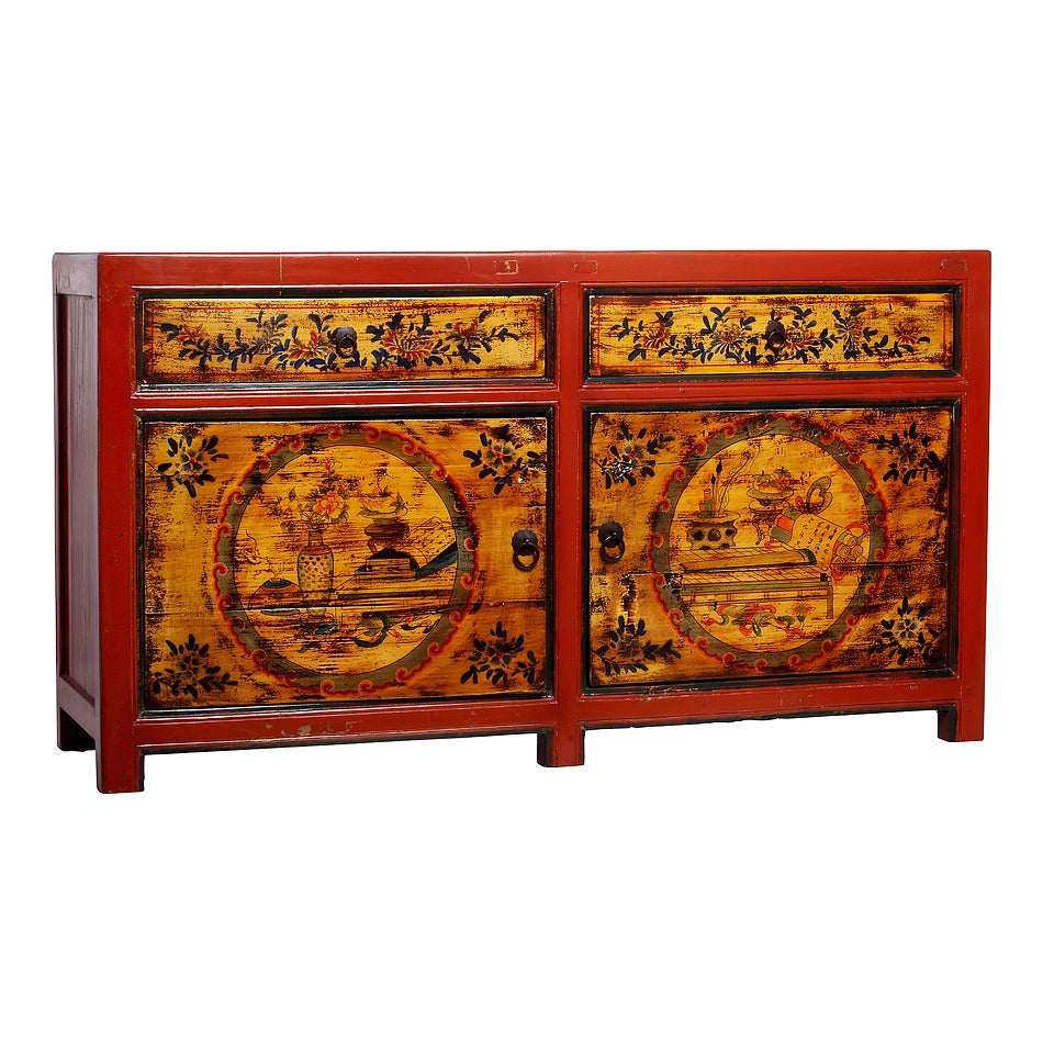 A Mongolian red lacquered two-drawer and two-door cabinet, hand-painted with black and gold accents from the late 19th century. This late 1800s cabinet features a linear red lacquered Silhouette, beautifully adorned on the front with a hand-painted
