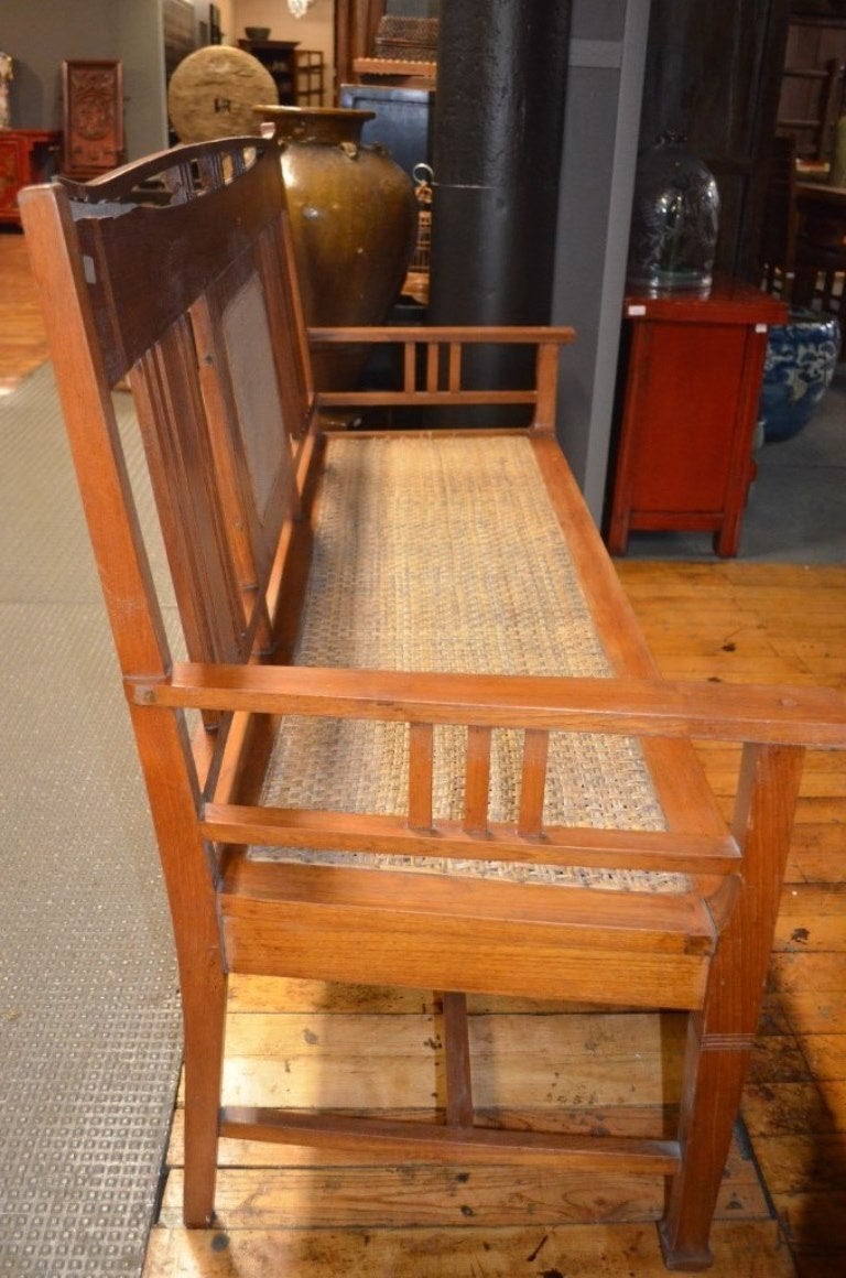 This Early 19th Century Java Teakwood Bench in Arts and Crafts Style Design. Woven Rattan Seat and Panel.