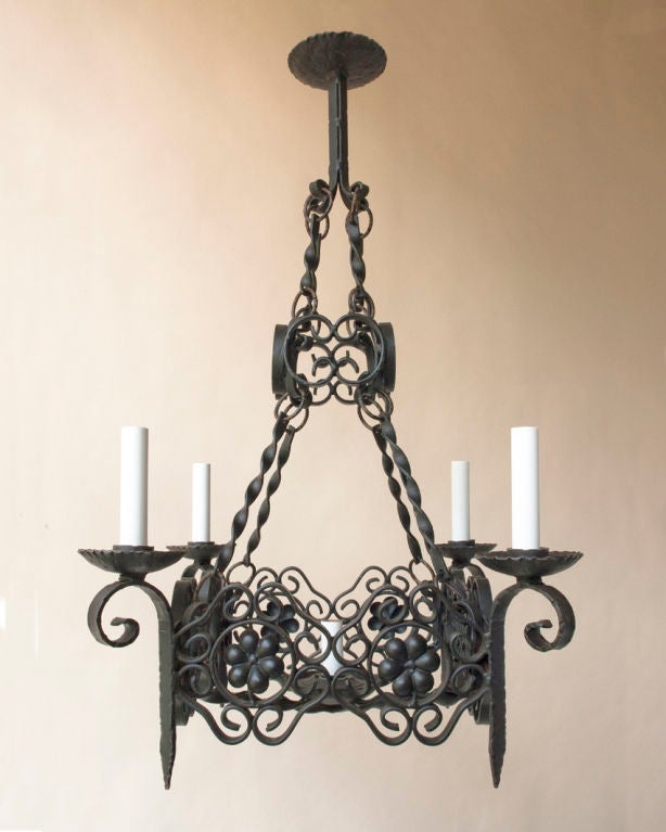 A square black painted iron five-light chandelier-wired for electricity, French, 20th century.

Measures: Square 16 1/2