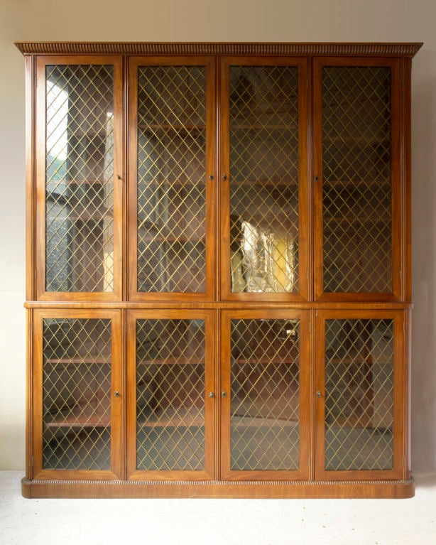 A fine mahogany deux corps bibliotheque, wood framed doors with inset glass and brass grill, gadrooned carved crown and base molding, English, 19th century<br />
Width-88½