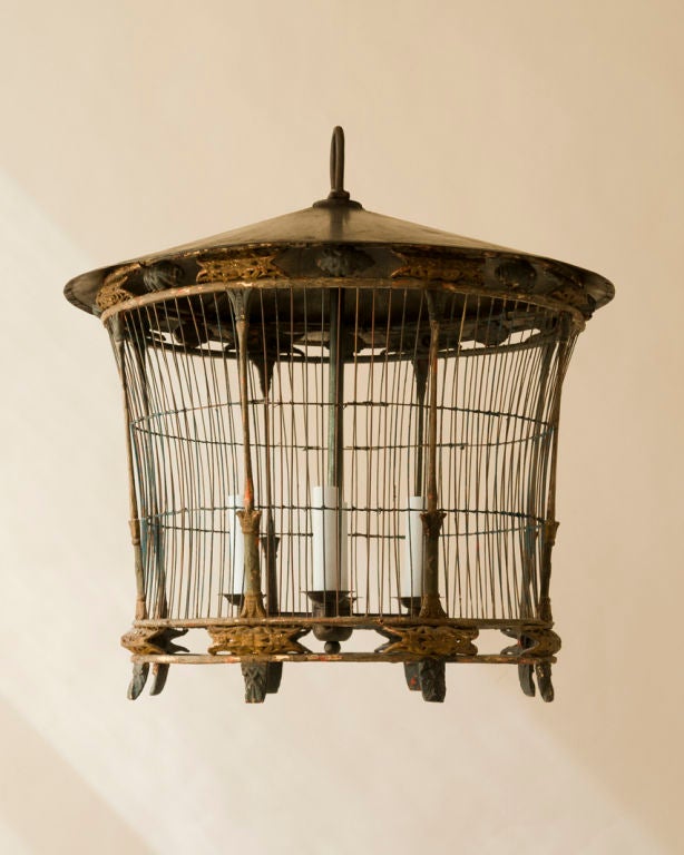 A round oriental style paper mache, wood & tole  bird cage, wired as a chandelier with 4 lights<br />
Diameter- 19”  Height- 17”