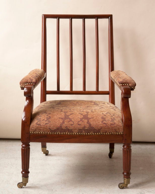 A Regency style mahogany open back low library chair, gadrooned carved front legs  & sabre back legs ending on bronze sabots with wheels, English or Continental   mid 19th, as is <br />
Width- 24