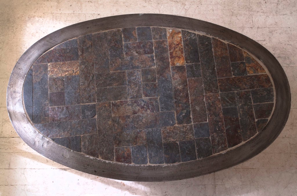 An unusual small steel and slate oval coffee table