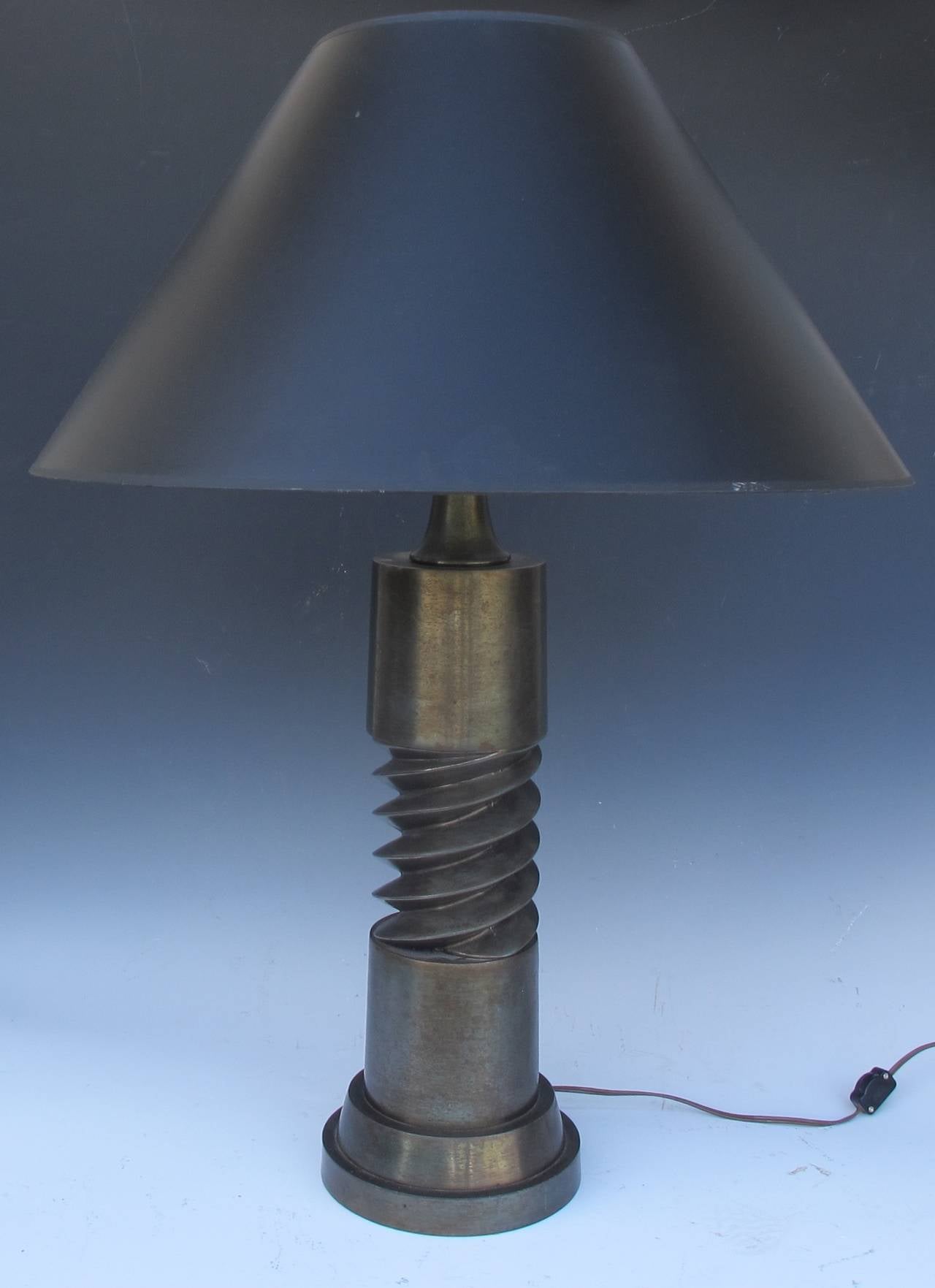 Patinated metal lamp with corkscrew design in center.