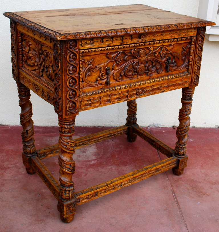 Very nice 18th Century Spanish Colonial side table with ornate figural and plant carving throughout. Vine like carving on legs with single drawer.