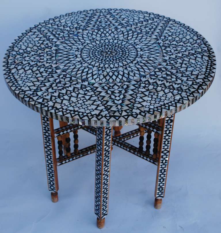Beautiful mid Century Moroccan folding coffee table. The base folds and the top can be removed for storage. Intricate mother of pearl and abalone inlay. Wood beads in between base stretchers.