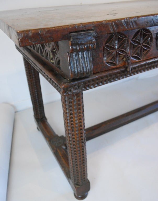 Exceptional, 17th Century Spanish table with a gorgeous single slab walnut top. Moresque carving through the drawers, legs and stretchers. Carved on both side with geometric Moorish circles. Iron hardware. Carved on both sides can float in a room.
