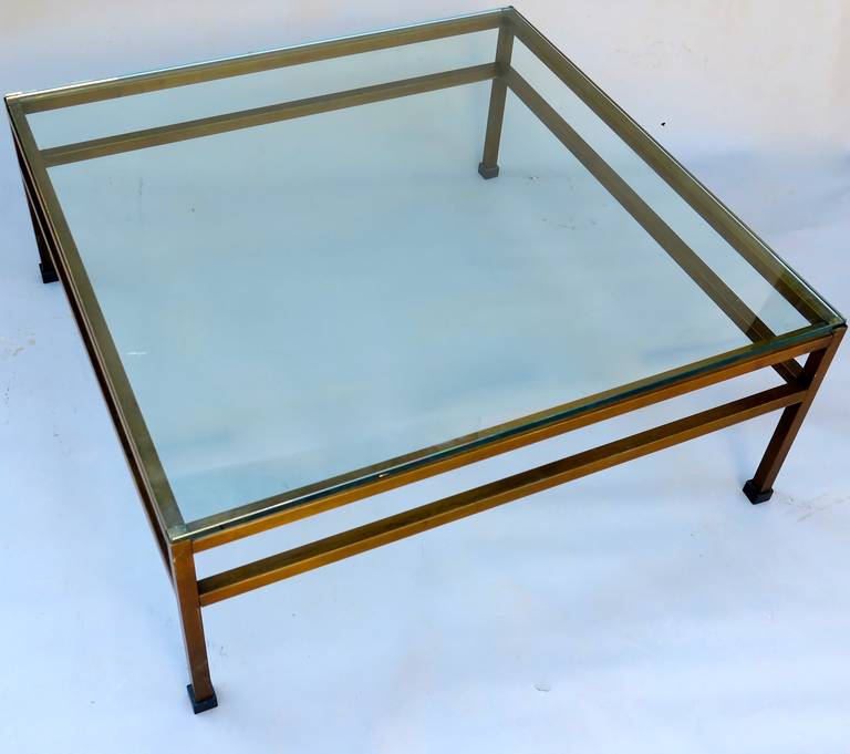 Very attractive pair of coffee tables with bronzed bases. Two tiered stretchers and thick glass tops.  Can be sold as pair of individually.