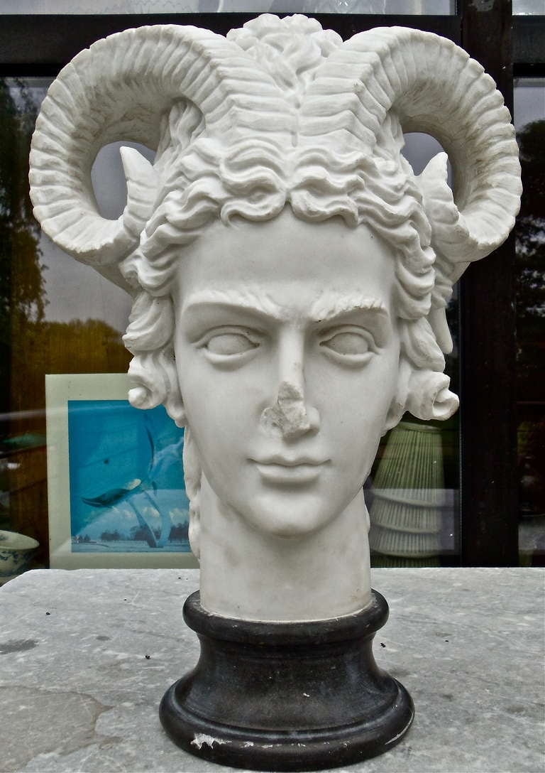 Unusual Carved Marble Bust or Head of a Helmeted Satyr or Pan

--Realistically Carved Male of Classical Form 
--Helmet on Reverse of a Goat Mask
--Fully Developed Goat or Ram's Horns
--Roman Representations of Satyr's Depicted Adult Males Often