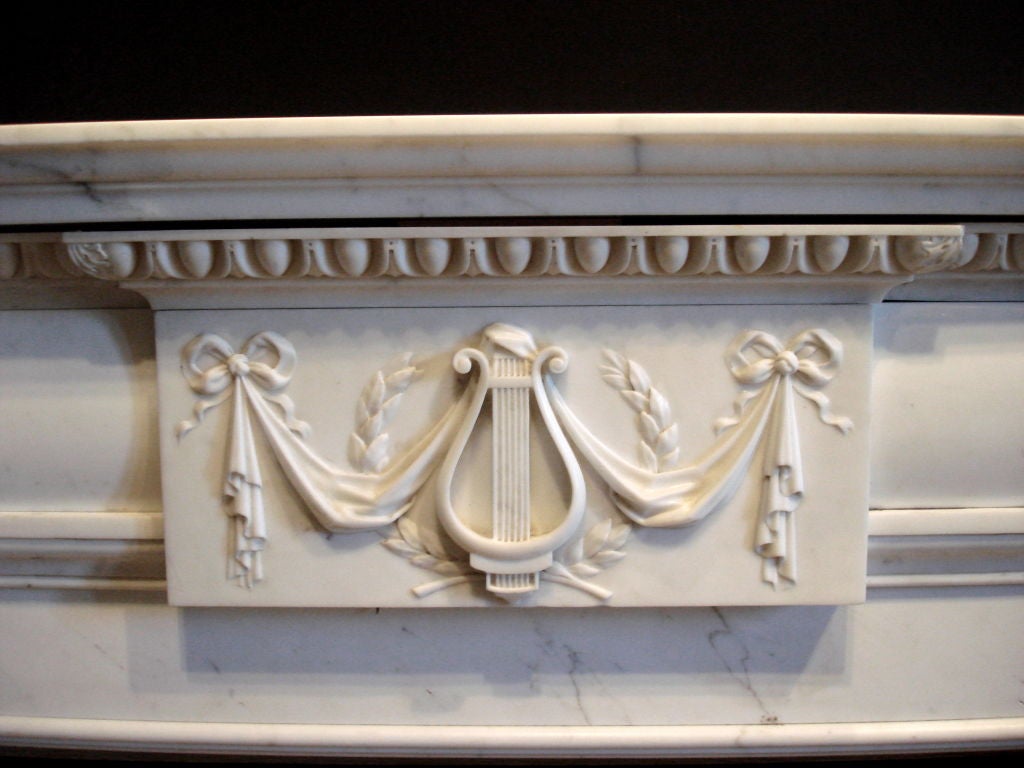 Beautiful White Statuario Marble Mantel or Chimneypiece.  Exquisitely hand carved in the Neoclassical taste.  Lyre, laurel and swag centerpiece