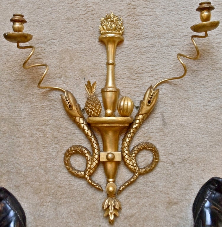 Pair of Interesting Neoclassical Giltwood Sconces.  Motif of Two Serpents Issuing Candle Arms.  Pineapple and Fruit with Torch.  Very much American, Very Much Folk Art.  Reminiscent of Early Samuel McIntyre Carvings though mid to late 19th century.