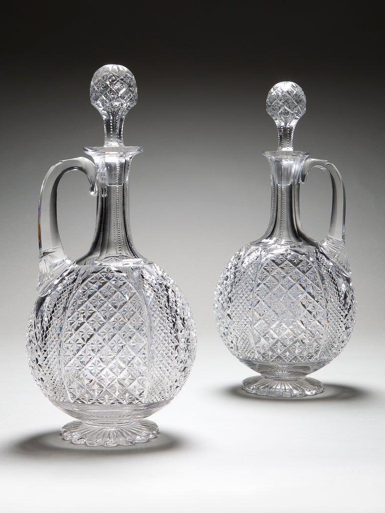 A pair of cut glass decanters with fine hobnail and diamond cut decoration, with their original stoppers. 