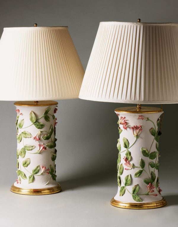 A pair of bisque-fired ceramic lamps with painted honeysuckle on a turned giltwood base by Clare Potter and Christopher Spitzmiller.