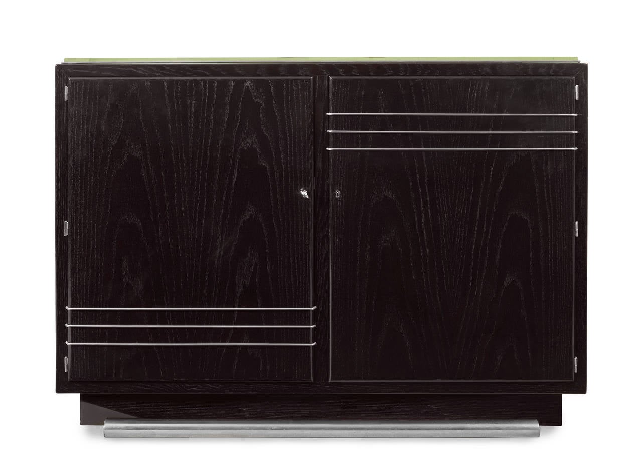 An extremely rare pair of French Art Deco ebonized oak cabinets by Maurice Jallot with mirror tops and aluminum bases, the double doors decorated with three elegant metal lines on the upper and lower parts. the interiors fitted with drawers and open