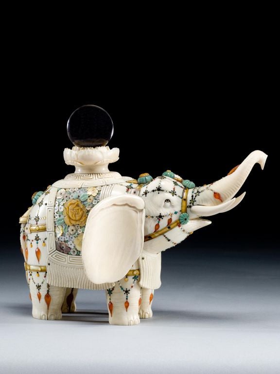 A fine quality Shibayama carved ivory elephant depicted with its trunk auspiciously raised and ornamented in the traditional manner with elaborate mother-of-pearl and semi-precious stone enrichments. Draped over the elephant's back is a blanket