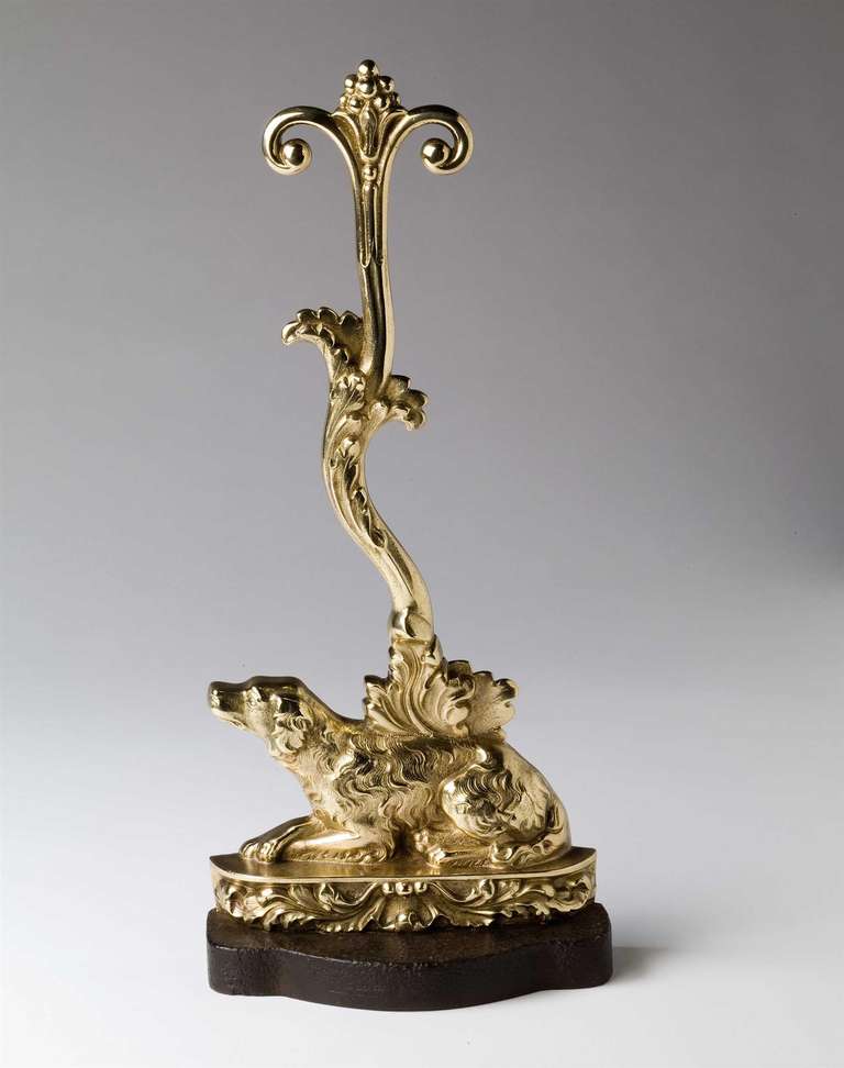 A Victorian polished brass door stop in the form of a seated dog with a foliate scrolling handle. 

This delightful doorstop of a finely modelled English setter at rest shaded by growing vines adorned with fruit is representative of the English