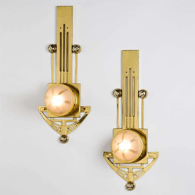 A pair of early 20th century brass wall lights with frosted cut glass cabouchon shades.
Attributed to Gustave Serrurier-Bovy.

Gustave Serrurier-Bovy (1858-1910) was one of the leading decorators bridging Arts and Craft and Art Nouveau in