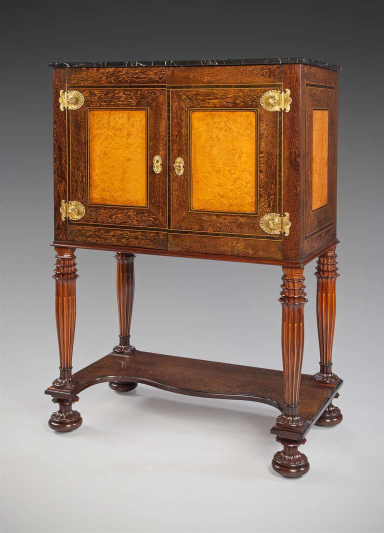 An art deco palm wood and burr walnut veneered cabinet on stand mounted in oriental-style gilt bronzes by Aflred Chambon, similar in design and materials to the safe and coin cabinet Chambon presented at the Exposition Universelle in Paris in 1925.